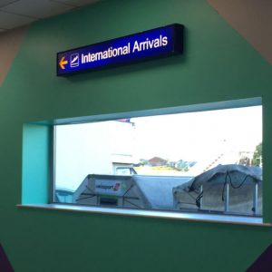 Signage at an airport pointing to the assembly area for international arrivals